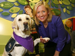 Sara Austin, CEO of the Sheldon Kennedy Child Advocacy Centre, poses with Webster, during a press conference on Monday, Oct. 1, 2018, marking the organization's fifth anniversary of the organization. Webster is one of two dogs used to provide emotional support to victims of child abuse.