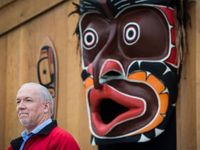 B.C. Premier John Horgan listens as a large First Nations carving of a mask is displayed during a ceremony before the raising of a replica Haida totem pole on the traditional territory of the Semiahmoo First Nation, at the Douglas-Peace Arch border crossing, in Surrey, B.C., on Friday September 21, 2018. The original pole was raised at the border crossing in the 1950s and removed without consultation or notice during the reconstruction of a visitor centre in 2008.