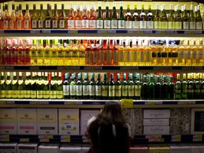 FILE- In this Nov. 27, 2012 file photo, a customer checks bottles of imported wine at a supermarket in Beijing. The World Health Organization said in a report published Friday Sept. 21, 2018, that drinking too much alcohol killed more than 3 million people in 2016, mostly men, with Europe having the highest global per capita alcohol consumption.