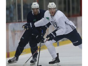 Then with the Winnipeg Jets, Buddy Robinson (foreground) and Brody Sutter participate in a drill during training camp in this September 2017 file photo. Postmedia file photo.