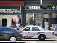 Pedestrians walk past The Green Room medical marijuana dispensary on Toronto's Spadina Avenue, Monday July 9, 2018.