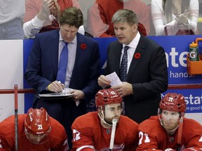 In this photo from Nov. 9, 2013, then-Detroit Red Wings head coach Mike Babcock and assistant coach Bill Peters talk during the overtime period of an NHL hockey game against the Tampa Bay Lighting in Detroit. AP file photo.