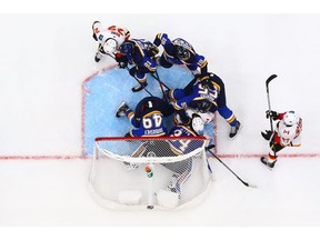 ST. LOUIS, MO - OCTOBER 11: Jake Allen #34 of the St. Louis Blues makes a save against Matthew Tkachuk #19 of the Calgary Flames at the Enterprise Center on October 11, 2018 in St. Louis, Missouri.