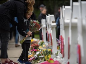 A mother and child place flowers at a memorial for victims of the mass shooting that killed 11 people and wounded 6 at the Tree Of Life Synagogue on October 29, 2018 in Pittsburgh, Pennsylvania. Eleven people were killed and six more wounded in the mass shooting that police say was fueled by antisemitism.