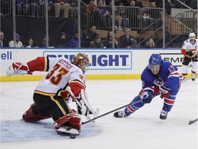 NEW YORK, NEW YORK - OCTOBER 21: David Rittich #33 of the Calgary Flames makes the second period stop on Jesper Fast #17 of the New York Rangers at Madison Square Garden on October 21, 2018 in New York City.