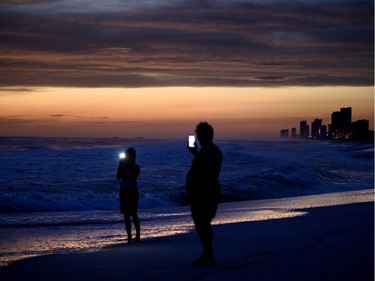 TOPSHOT - People visit the beach while waiting for Hurricane Michael October 9, 2018 in Panama City Beach, Florida.