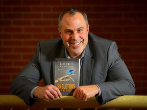 Calgary police detective Dave Sweet poses with his newly published book, Skeletons In My Closet, which he co-wrote with Sarah Graham.