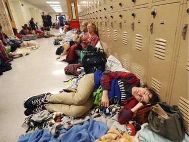 Emily Hindle lies on the floor at an evacuation shelter set up at Rutherford High School, in advance of Hurricane Michael, which is expected to make landfall today, in Panama City Beach, Fla., Wednesday, Oct. 10, 2018.