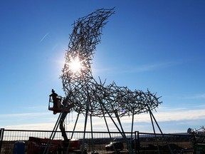 Workers continue to install public artwork Ascend on the hill east of the Shane Homes YMCA at Rocky Ridge on Monday, Oct. 29, 2018