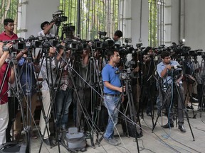 FILE- In this May 3, 2016 file photo, Bangladeshi journalists cover proceedings outside a court in Dhaka, Bangladesh. An influential body of newspaper editors in Bangladesh has criticized the government for a new digital security law that they say will stifle constitutionally protected freedom of speech and curtail press freedom. The Editors' Council told a news conference on Saturday, oct. 13, 2018 in the nation's capital, Dhaka, that they were not pleased that the bill was made a law despite their objections.