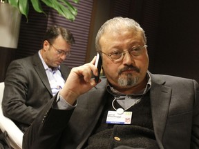 FILE - In this Jan. 29, 2011 file photo, Saudi journalist Jamal Khashoggi speaks on his cellphone at the World Economic Forum in Davos, Switzerland. Khashoggi was a Saudi insider. He rubbed shoulders with the Saudi royal family and supported its efforts to nudge the entrenched ultraconservative clerics to accept reforms. He was a close aide to the kingdom's former spy chief and was a leading voice in the country's prominent dailies. In a dramatic twist of fate, Khashoggi disappeared on Tuesday, Oct. 2, 2018, after visiting his country's consulate in Istanbul and may have been killed there.