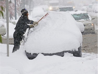 Edward Nyikes clears snow from his car in Crescent Heights on Tuesday afternoon, Oct. 2, 2018.