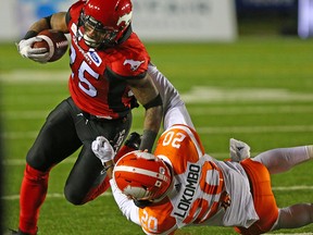 The Calgary Stampeders' Don Jackson is grabbed by the B.C. Lions' Bo Lokombo during CFL action at McMahon Stadium in Calgary on Saturday, October 13, 2018.