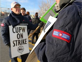 Striking postal workers walk a picket line at the northeast Calgary sorting centre onThursday October 25, 2018. Gavin Young/Postmedia