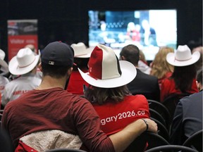 An overflow crowd in the lobby of City Hall watches as Calgary 2026 BidCo's Mary Moran and Scott Scott Hutcheson answer council questions before a vote on a motion to end the 2026 Olympic bid process on Wednesday October 31, 2018.  Gavin Young/Postmedia