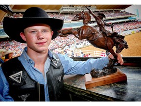 Dawson Hay of Wildwood, Alberta poses for a photo with his trophy bronze after winner the 2017 novice saddle bronc competition at the Calgary Stampede rodeo. AL CHAREST/POSTMEDIA