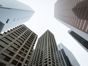 Highrise buildings stand in downtown Calgary. Recent deal announcements have been followed by massive share price drops, which has led some oil and gas companies to reconsider mergers and acquisitions.