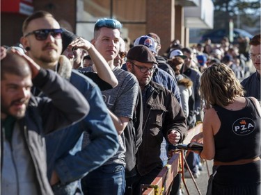 Cafe employees offer coffee to people lining-up to purchase legal cannabis in Calgary, Alta., Wednesday, Oct. 17, 2018.