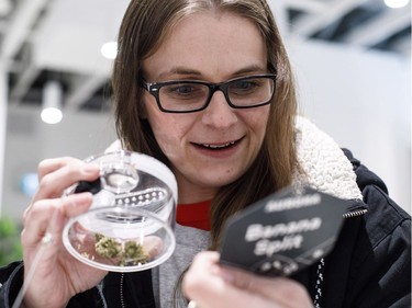 Whitney Stewart looks over samples of cannabis at the opening of Fire and Flower as customers are now allowed to purchase legal marijuana, in Edmonton, Alta., on Wednesday, October 17, 2018.