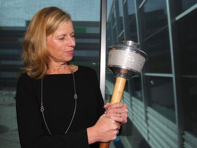 Mary Moran, CEO of Calgary 2026, holds a 1988 Olympic Torch during the Celebration of Sport 2018 held at Winsport in Calgary on Thursday, October 11, 2018. Moran spoke about the benefits of hosting the 2026 Olympic games to the crowd of sport supporters and sponsors. Jim Wells/Postmedia