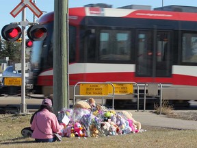Jennifer Hung meditates at the scene on Tuesday, October 16, 2018 where a young girl was struck and killed by a CTrain on Monday morning. She also placed a small stuffed animal and a card for the family. Hung said she could feel the girl's spirit at the scene as he used the Heart Sutra. Jim Wells/Postmedia