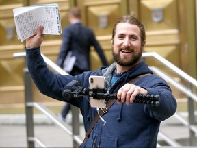 David Stephan records a blog outside the Calgary Courts Centre on the Jennifer and Jeromie Clark trial in Calgary on Monday Oct. 1, 2018. Stephan and wife Collet are awaiting a new trial for the 2012 death of their 19-month-old son Ezekiel.