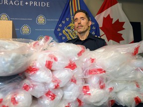 Calgary police Insp. Keith Cain shows some of the drugs seized in a record-breaking bust. Following a three-month investigation, cocaine and methamphetamine with a street value of approximately $8 million were seized from a minivan.