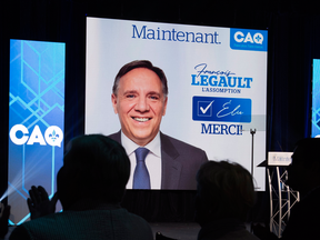 Coalition Avenir Quebec supporters watch the election results with their leader leader Francois Legault on the giant screen in Quebec City.