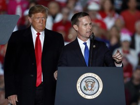 President Donald Trump listens as U.S. Rep. Rodney Davis, R-Ill, speaks during a rally at Southern Illinois Airport Saturday, Oct. 27, 2018, in Murphysboro, Ill.
