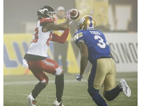Calgary Stampeders' Markeith Ambles (83) catches the touchdown pass as Winnipeg Blue Bombers' Kevin Fogg (3) defends during the second half of CFL action in Winnipeg, Friday, Oct. 26, 2018.