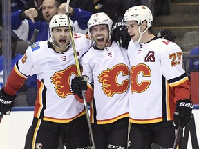 Calgary Flames Elias Lindholm (centre) celebrates his goal with defenceman Mark Giordano and Sean Monahan in the third period against the Toronto Maple Leafs in Toronto on Monday, Oct. 29, 2018.