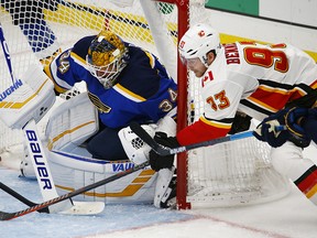 St. Louis Blues goaltender Jake Allen keeps his eyes on the puck as Calgary Flames' Sam Bennett, right, gets off a shot during the third period of an NHL hockey game Thursday, Oct. 11, 2018, in St. Louis. The Blues won 5-3.