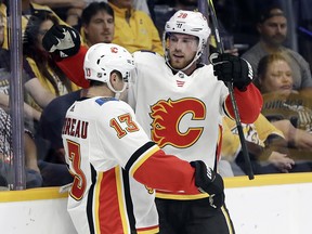 Flames centre Elias Lindholm celebrates with Johnny Gaudreau after Lindholm scored against the Nashville Predators in the first period on Tuesday, Oct. 9, 2018, in Nashville, Tenn.