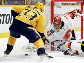 Calgary Flames goalie David Rittich blocks a shot in front of Nashville Predators left-winger Viktor Arvidsson in the second period of an NHL hockey game Thursday, Feb. 15, 2018, in Nashville, Tenn.