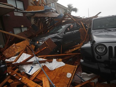 A storm chaser climbs into his vehicle during the eye of Hurricane Michael to retrieve equipment after a hotel canopy collapsed in Panama City Beach, Fla., Wednesday, Oct. 10, 2018. (AP Photo/Gerald Herbert) ORG XMIT: FLGH118