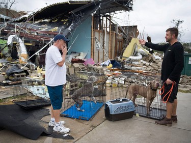 PANAMA CITY, FL - OCTOBER 10: Rick Teska (L) helps a business owner rescue his dogs from the damagd business after hurricane Michael passed through the area on October 10, 2018 in Panama City, Florida. The hurricane hit the Florida Panhandle as a category 4 storm.  (Photo by Joe Raedle/Getty Images)