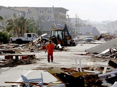 Robert Brock, 27, of Mexico Beach, Fla., walks westbound on US 98 through the coastal township, population 1200, which lay devastated on Thursday, Oct 11, 2018, after Hurricane Michael made landfall on Wednesday in the Florida Panhandle. Brock said he stayed in the city to ride out the storm. (Douglas R. Clifford/Tampa Bay Times via AP) ORG XMIT: FLPET102