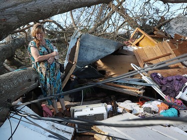 PANAMA CITY, FL - OCTOBER 11:  Kathy Coy stands among what is left of her home after Hurricane Michael destroyed it on October 11, 2018 in Panama City, Florida. She said she was in the home when it was blown apart and is thankful to be alive. The hurricane hit the Florida Panhandle as a category 4 storm.  (Photo by Joe Raedle/Getty Images)