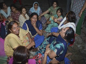 Indian women mourn the death of a relative, victim of a train accident, outside a hospital in Amritsar, India, Friday, Oct. 19, 2018. A speeding train ran over a crowd watching fireworks during a religious festival in northern India on Friday, killing at least 50 people, a Congress party leader said. (AP Photo/Prabhjot Gill) ORG XMIT: ASR111