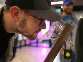 Cole Hendry, 25, smells cannabis at Nova Cannabis on opening day in Calgary, on Oct. 17, 2018.