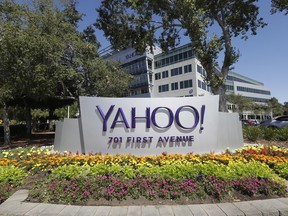 FILE- In this July 19, 2016, file photo, flowers bloom in front of a Yahoo sign at the company's headquarters in Sunnyvale, Calif. Yahoo has agreed to pay $50 million in damages and provide two years of free credit-monitoring services to about 200 million people in the U.S. and Israel whose email addresses and other personal information were stolen as part of the biggest security breach in history.