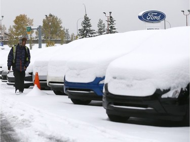 Thick snow blanketed cars at NorthStar Ford Sales in northwest Calgary on Tuesday, Oct. 2, 2018.