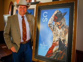 Calgary Stampede chairman and president Dana Peers with the 2019 Calgary Stampede poster created by Rebecca Shuttleworth.