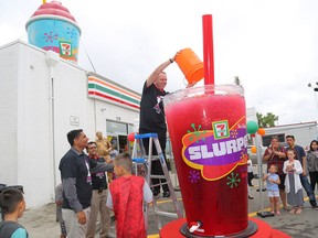 Vice president and general manager of 7-Eleven Canada Doug Rosencrans pours the last bit of Slurpee to fill the world's largest Slurpee cup during 7-Eleven Day festivities in Winnipeg on July 11, 2017.