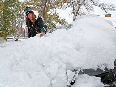 Edward Nyikes cleans snow from his car in Crescent Heights on Tuesday afternoon, Oct. 2, 2018.