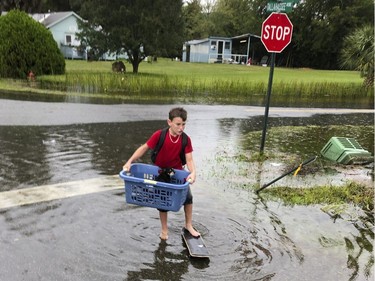 Jayden Morgan, 11, evacuates his home as water starts to flood his neighborhood in St. Marks, Fla, ahead of Hurricane Michael. Gaining fury with every passing hour, Hurricane Michael closed in Wednesday on the Florida Panhandle with potentially catastrophic winds of 150 mph, the most powerful storm on record ever to menace the stretch of fishing towns, military bases and spring-break beaches.