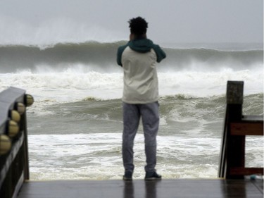 A beachgoer takes photos of the waves on Wednesday Oct. 10, 2018, at The Boardwalk on Okaloosa Island in Fort Walton Beach, Fla., as Hurricane Michael impacts the coast. (Nick Tomecek/Northwest Florida Daily News via AP) ORG XMIT: FLPLA102