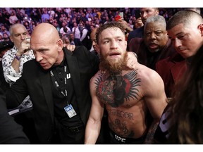 Conor McGregor is escorted from the cage area after fighting Khabib Nurmagomedov in a lightweight title mixed martial arts bout at UFC 229 in Las Vegas, Saturday, Oct. 6, 2018. Nurmagomedov won the fight by submission during the fourth round to retain the title.