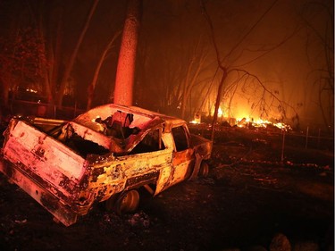 A burned out car sits  in front of a home that was consumed by the Camp Fire on Nov. 8, 2018 in Paradise, California. Fueled by high winds and low humidity, the rapidly spreading wildfire has ripped through the town of Paradise, charring 18,000 acres and destroying dozens of homes in a matter of hours. The fire is currently at zero containment.