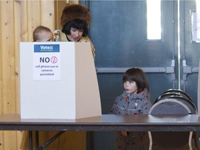 Anna Coe with her children Beatrice, 4, and Izzy, 11 months, votes during the second day of advance voting in Calgary's Olympic plebiscite at the Scandinavian Club in on Wednesday November 7, 2018. Leah Hennel/Postmedia